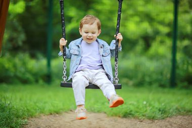 Bahar geldi, baharda bir çocuk sallanıyor salıncakta, keyifli bir çocukluk dönemi mutlu bir yaz çocuğu.