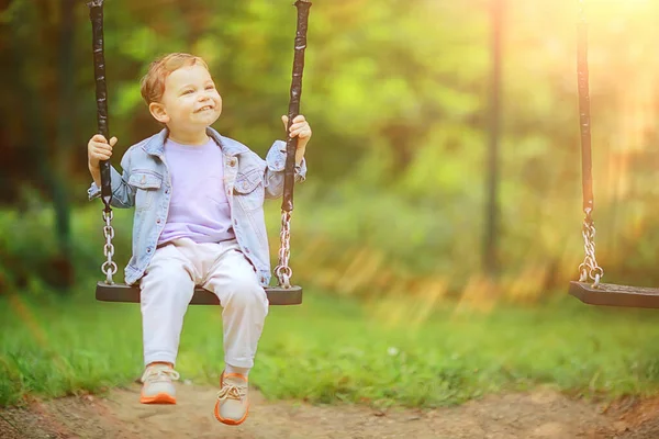 春の男の子がスイングし レジャーを楽しむ子供の頃の夏の幸せな子供 — ストック写真