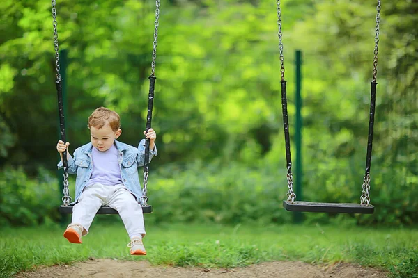 春の男の子がスイングし レジャーを楽しむ子供の頃の夏の幸せな子供 — ストック写真