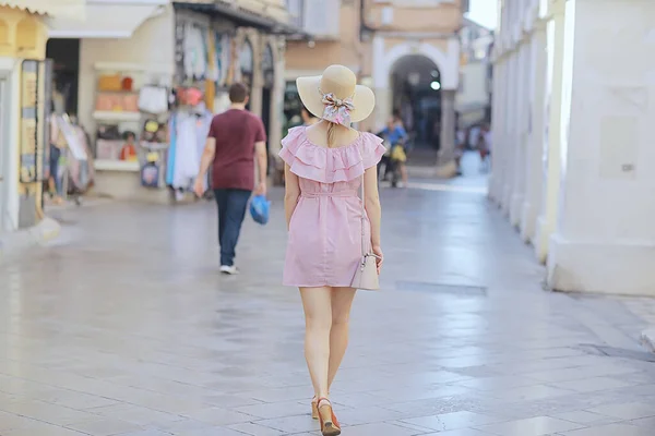 tourism summer old town female, europe mediterranean, young woman traveler, back straw hat view