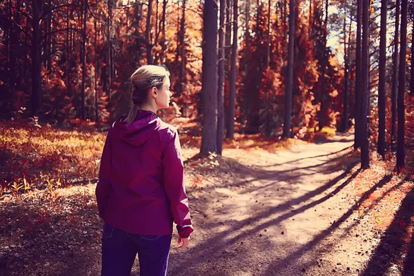女性のスポーツスタイル秋の森黄色の公園の葉の秋の太陽の下でフィットネス観光 — ストック写真