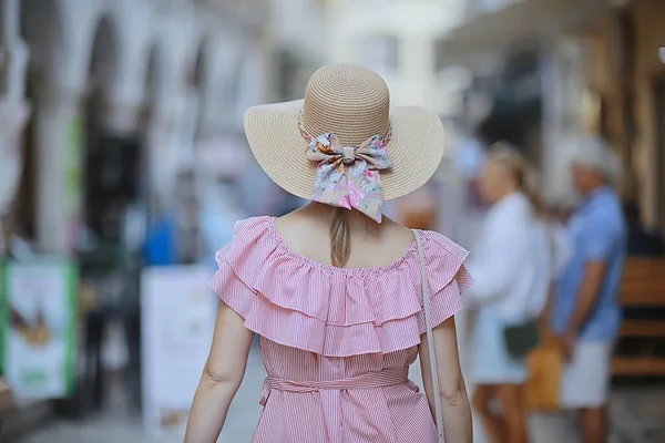 tourism summer old town female, europe mediterranean, young woman traveler, back straw hat view