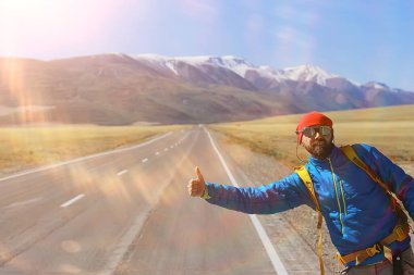 Sırt çantalı bir gezgin otostop çekiyor, seyahat ediyor.