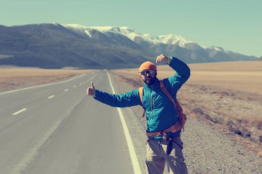 Sırt çantalı bir gezgin otostop çekiyor, seyahat ediyor.
