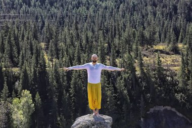 Budizm meditasyon seyahati, insan doğada geleneksel sarı pantolonla yoga yapıyor.