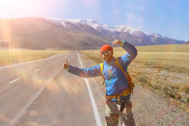Sırt çantalı bir gezgin otostop çekiyor, seyahat ediyor.