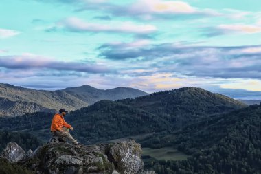 Adam dağlarda oturuyor, erkek turist yaz tatilinde.