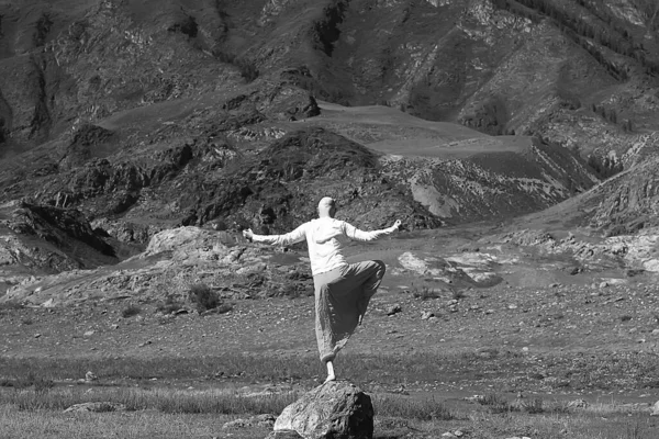 仏教の瞑想旅行 男は自然の中で伝統的な黄色のパンツでヨガをやって — ストック写真