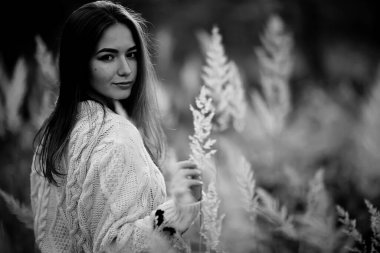 Siyah beyaz, neşeli bir kızın taşra tarzı portresi, saman tarlasında özgürlüğüne kavuşmuş genç bir kadın.