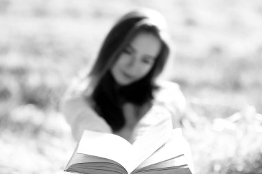 Yazın tarlada kitap okuyan bir kadın bir kitap okuyor. Bir kitap okuyor. Okul kızından yaz tatilini tarlada okuyor.