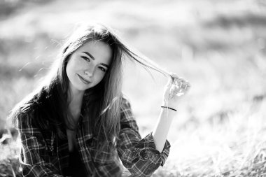 Siyah beyaz, neşeli bir kızın taşra tarzı portresi, saman tarlasında özgürlüğüne kavuşmuş genç bir kadın.