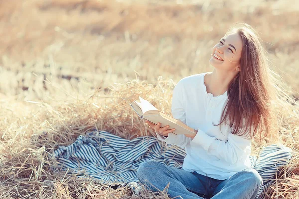 女がフィールドで本を読む夏のわら女がフィールドの女子学生から夏休みを勉強する本を読む — ストック写真