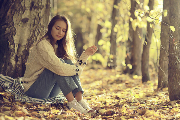 Sad girl in autumn park, stress loneliness young person female