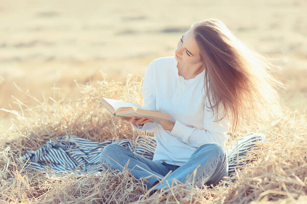 female reading a book in a field summer straw woman reading a book student studying summer vacation from school girl in the field