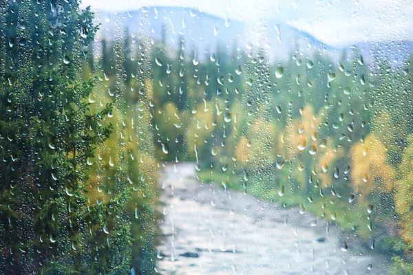 rain window view, water drops on glass view forest and mountains landscape background