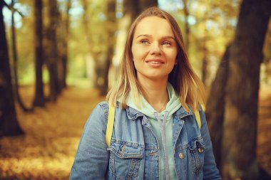 Annem sonbahar parkında yürüyüş için bebek arabasıyla gezer, sonbahar manzarası Ekim ayı sarı park manzarası