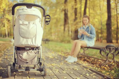 Arka bacaklardan bebek arabası görüntüsü, anne sonbahar soyut arka plan parçası yürür