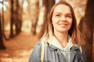 Annem sonbahar parkında yürüyüş için bebek arabasıyla gezer, sonbahar manzarası Ekim ayı sarı park manzarası