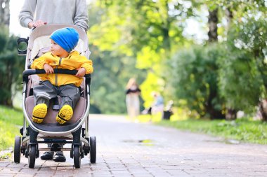Bir bebek arabasında sonbahar yürüyüşü çocuk, sokak şehir manzarası