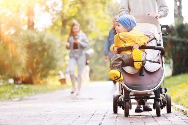 Bir bebek arabasında sonbahar yürüyüşü çocuk, sokak şehir manzarası