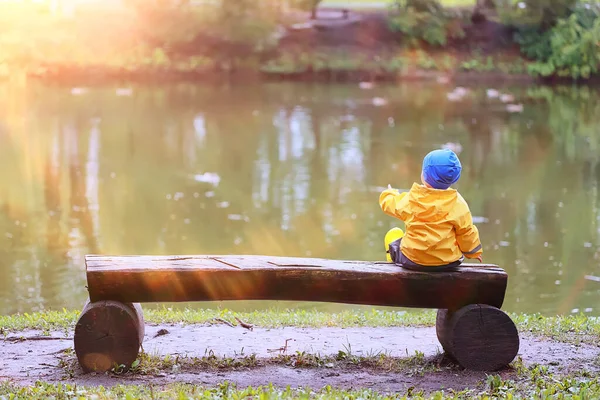 子供公園レインコート黄色 楽しい季節のぬれた防水屋外服 — ストック写真