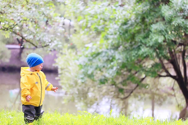 子供公園レインコート黄色 楽しい季節のぬれた防水屋外服 — ストック写真
