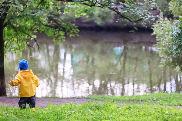 子供公園レインコート黄色 楽しい季節のぬれた防水屋外服 — ストック写真