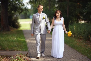 Gelin ve damat parkta yürüyor