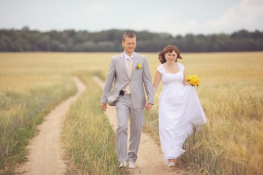Gelin ve damat buğday alan üzerinde yürüme