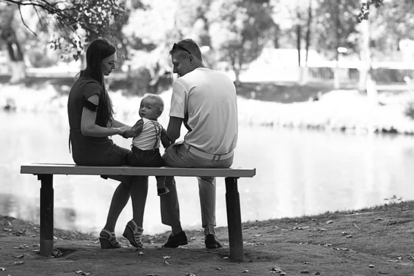 Family with child sitting on the bench — Stock Photo, Image
