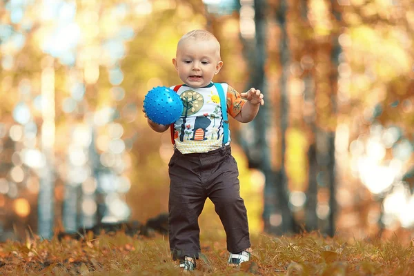 Дитина грає з м'ячем у парку — стокове фото