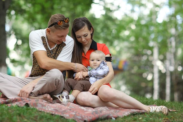 Familia joven con niño en el parque — Foto de Stock