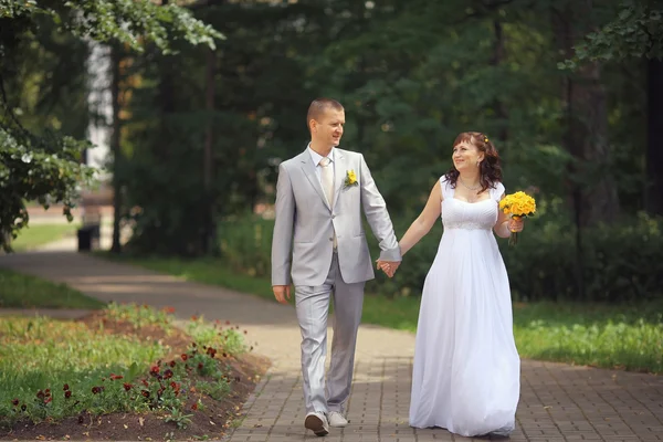 Noiva e noivo andando no parque — Fotografia de Stock