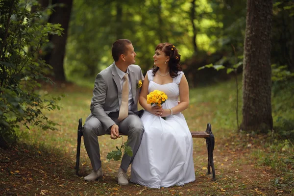 Жених и невеста сидят на скамейке — стоковое фото