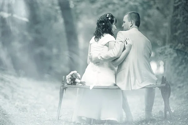 Nevěsta a ženich seděl na lavičce — Stock fotografie