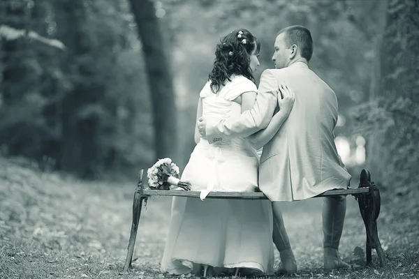 Bride and groom sitting on the bench — Stock Photo, Image