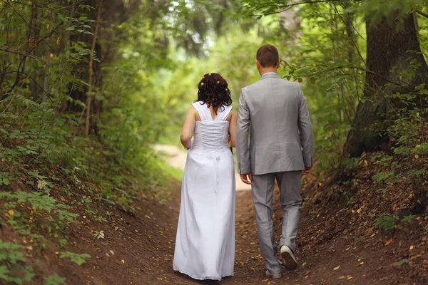 Brud och brudgum promenader i parken — Stockfoto