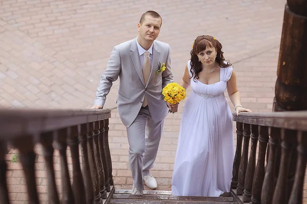 Bride and groom near wooden stairs — Stock Photo, Image