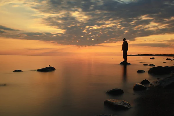 Muž na jezeře na sunset — Stock fotografie