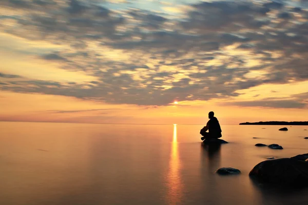 Muž na jezeře na sunset — Stock fotografie