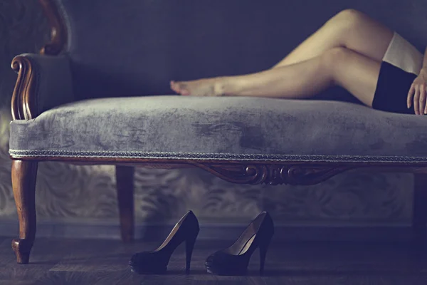 Hermosa mujer piernas en el sofá — Foto de Stock