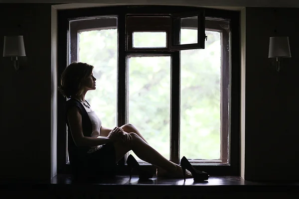 Woman sitting on the windowsill — Stock Photo, Image