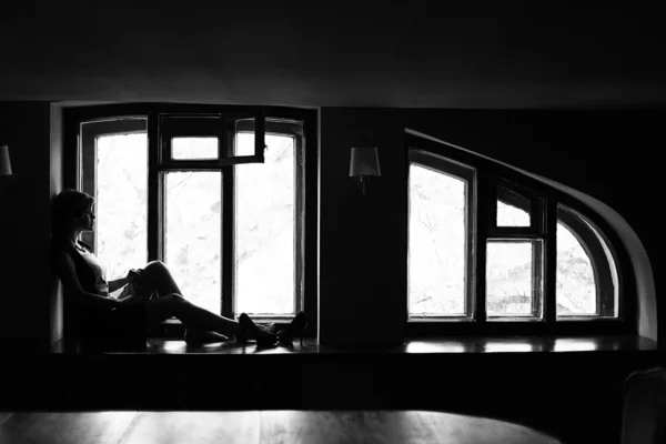 Woman sitting on the windowsill — Stock Photo, Image