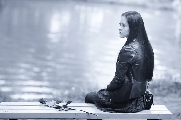 Lonely girl sitting on the bench — Stock Photo, Image