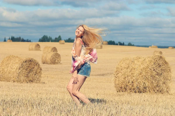 Blondine springt in Feld — Stockfoto