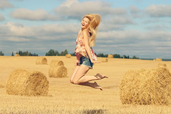 Blondýnka skáče v poli — Stock fotografie