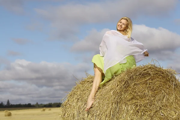 Blond kvinna sitter på hö — Stockfoto