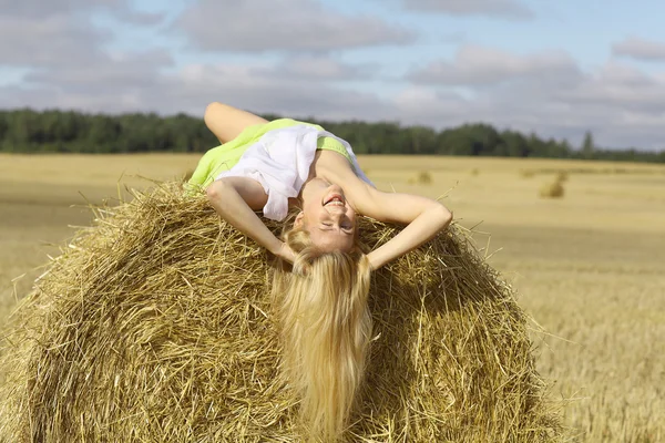 干し草に横になっている金髪の女性 — ストック写真