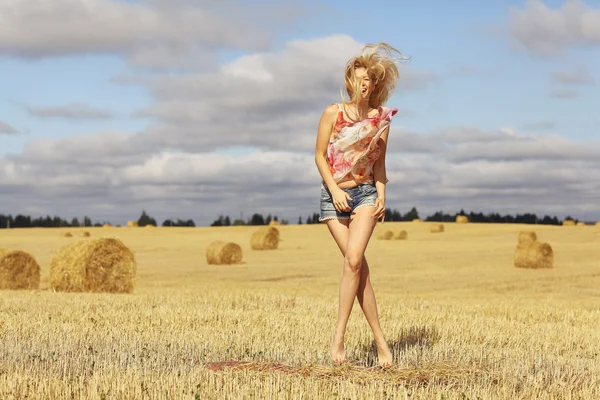 Bionda donna salta in campo — Foto Stock