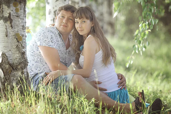 Homme et femme enceinte couchés sur l'herbe — Photo